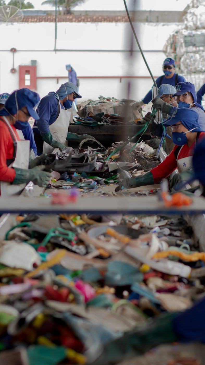 Linha de triagem industrial da VKL Reciclados — equipe realizando separação de materiais plásticos na esteira